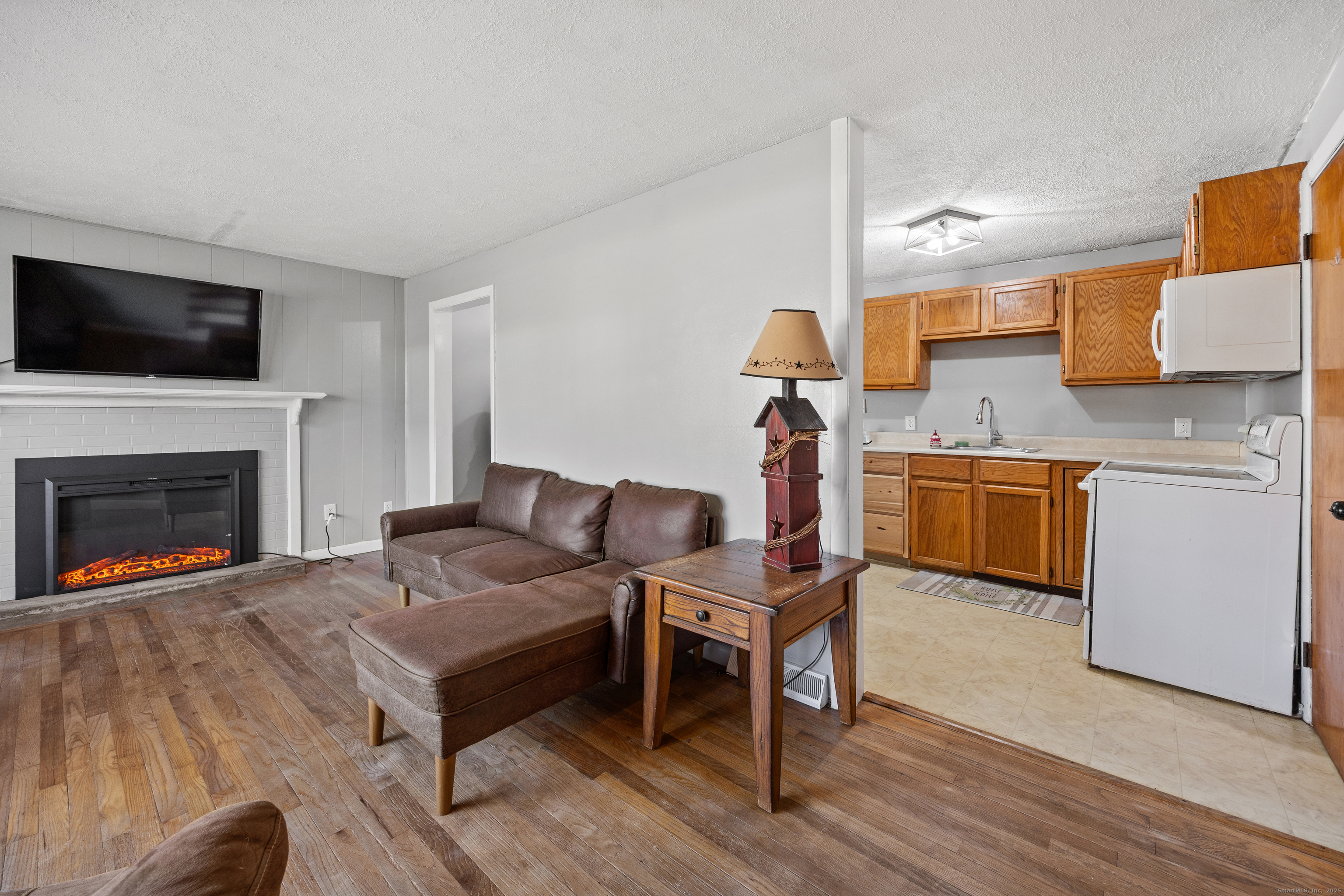 122 North Airline Road Wallingford, CT 06492 - Photo 7 of 33 a living room with furniture a flat screen tv and a fireplace