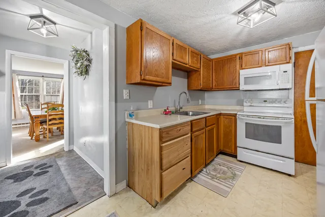 a kitchen with white cabinets and white appliances