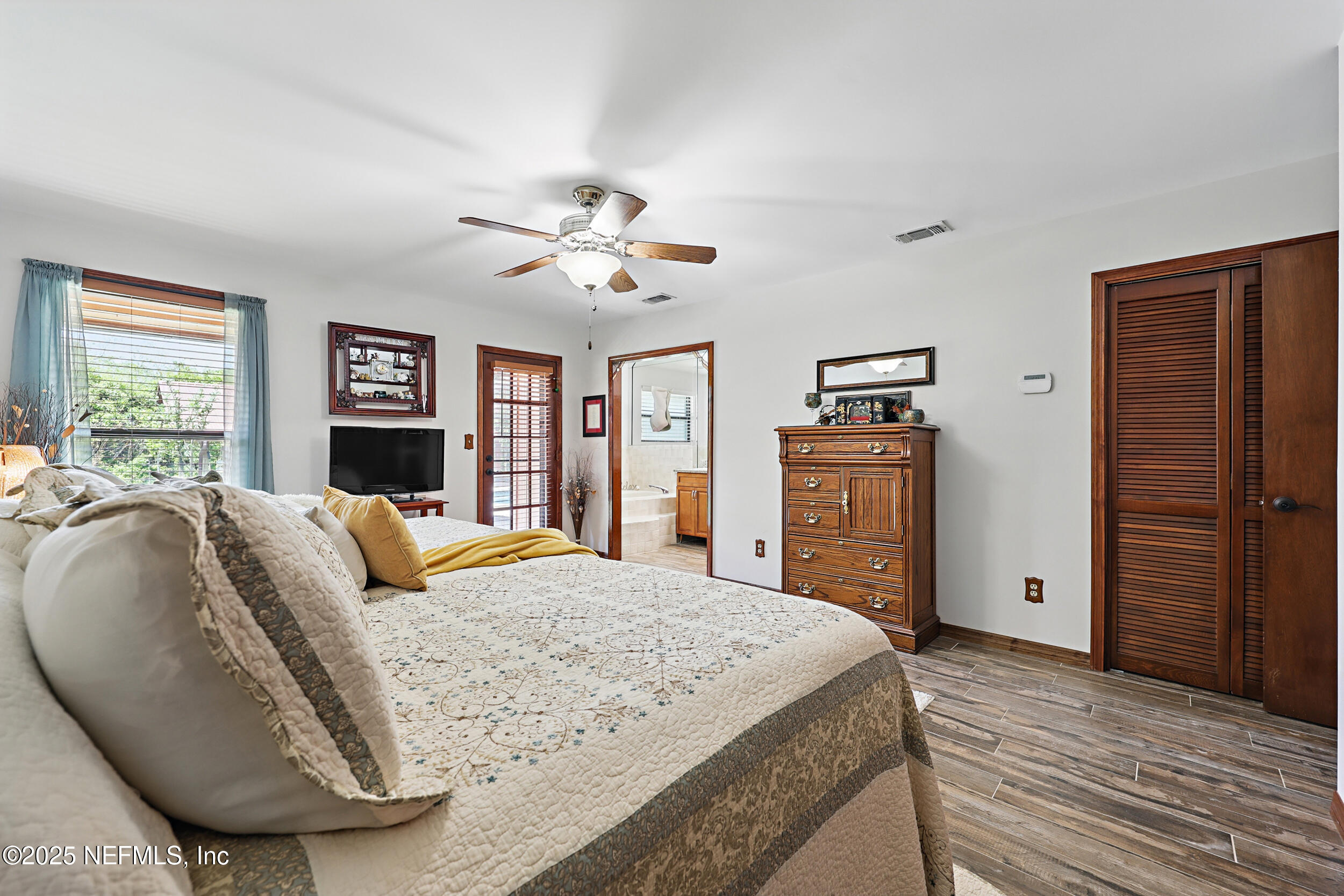 3154 Brooks Road Fleming Island, FL 32003 - Photo 23 of 53 a bedroom with a large bed a chandelier and dresser