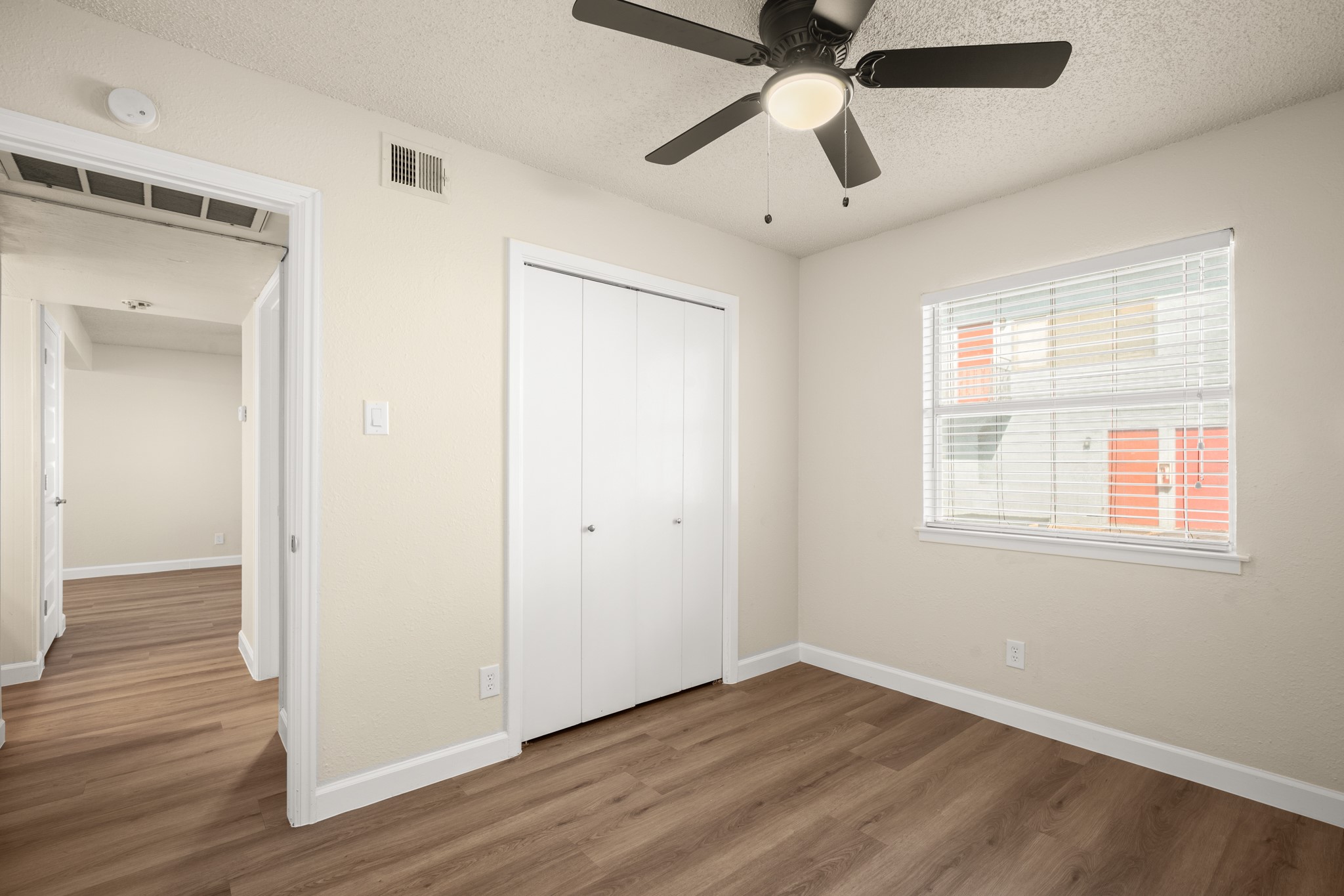 2408 Longview Street, Unit 112 Austin, TX 78705 - Photo 12 of 15 a view of an empty room with wooden floor and a window