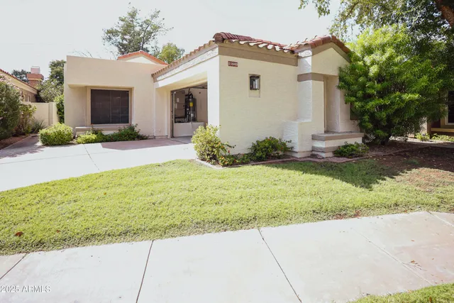 a view of a white house with a yard and plants