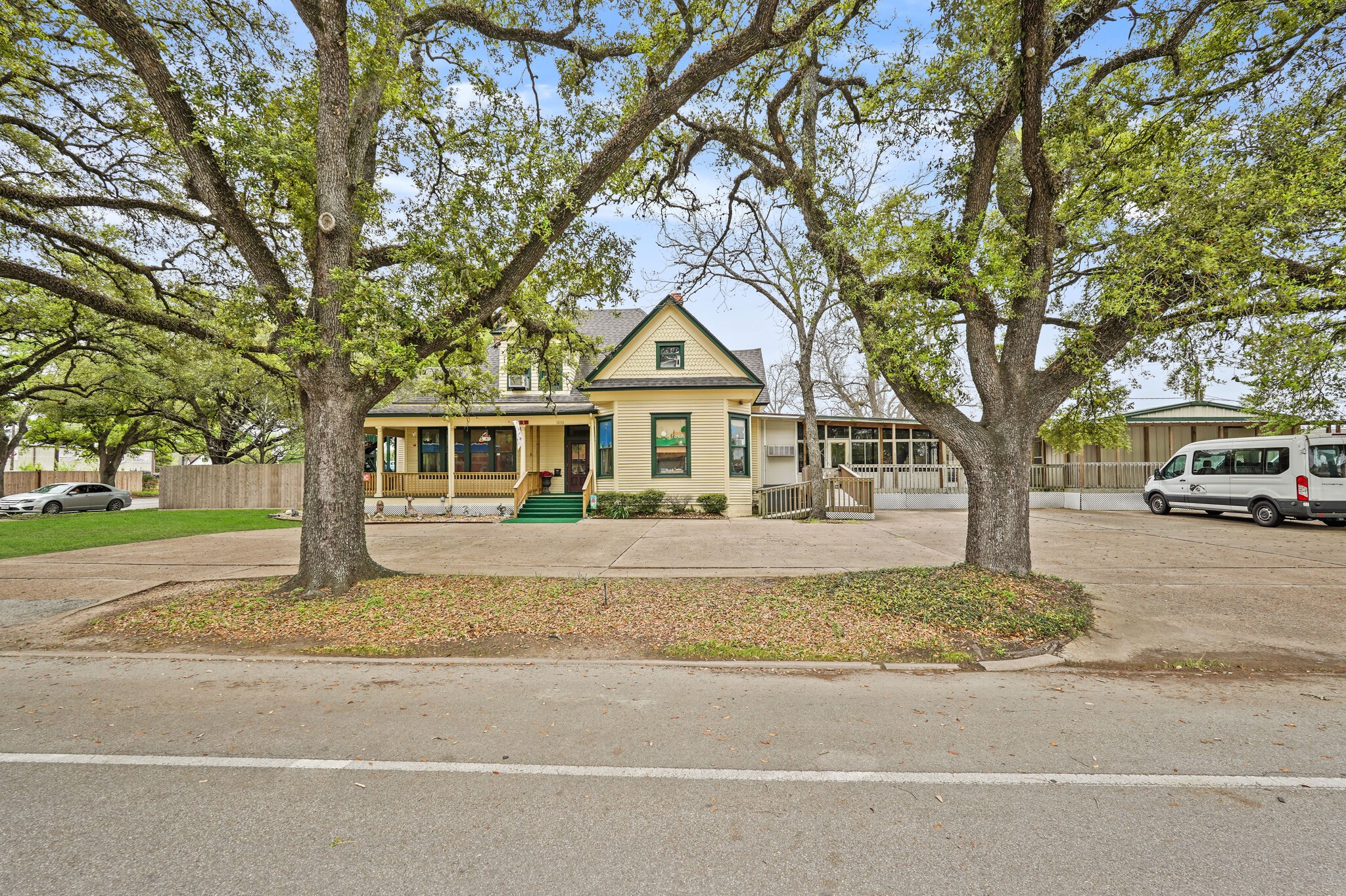a front view of a house with a garden and trees