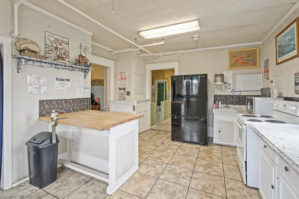 a kitchen with a stove top oven and refrigerator
