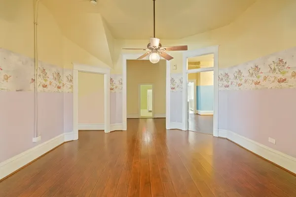 a view of a livingroom with wooden floor and a ceiling fan