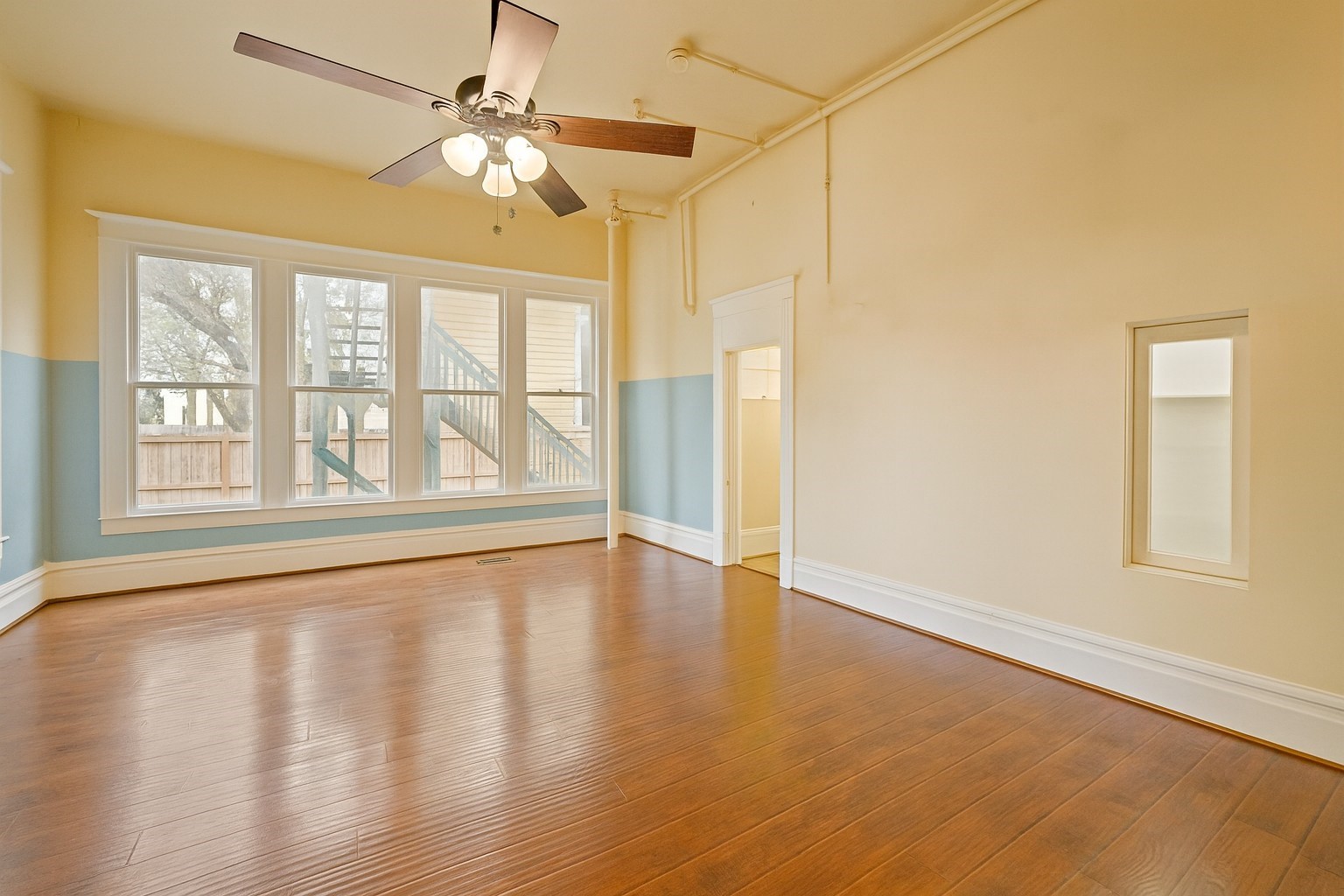 1030 4th Street Rosenberg, TX 77471 - Photo 10 of 38 a view of an empty room with a window and wooden floor