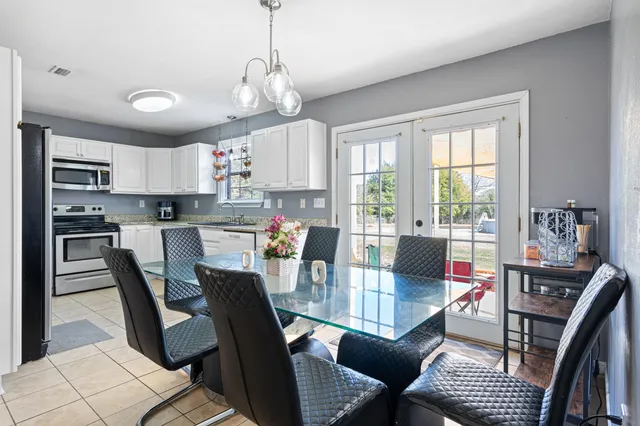 a kitchen with granite countertop white cabinets stainless steel appliances and a counter space