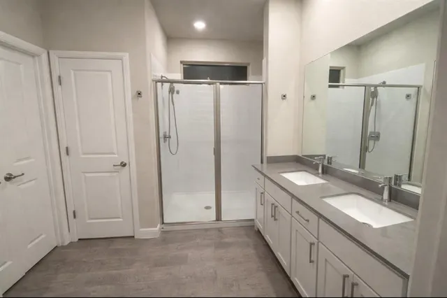 a bathroom with double vanity sink and a mirror