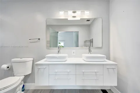 a bedroom with a bed lamps and wooden floor