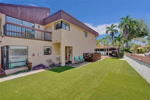an aerial view of a house with swimming pool and outdoor seating
