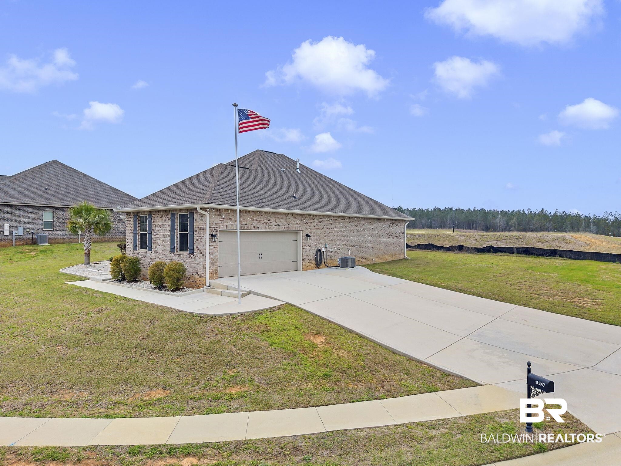 11247 Thistledown Loop Spanish Fort, AL 36527 - Photo 48 of 72 View of front facade featuring a garage, a front yard, brick siding, and driveway