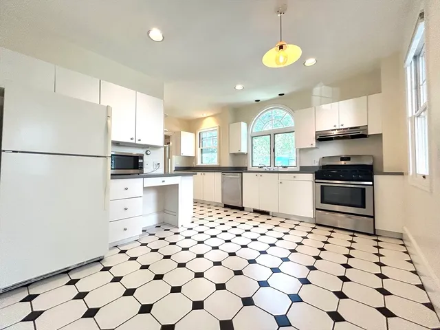 a kitchen with stainless steel appliances a refrigerator sink and cabinets