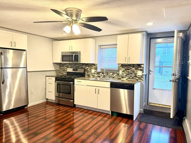 a kitchen with granite countertop a refrigerator and a stove top oven