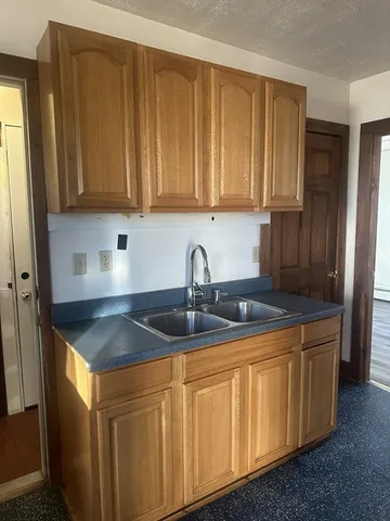 a large kitchen with granite countertop a sink stainless steel appliances and cabinets