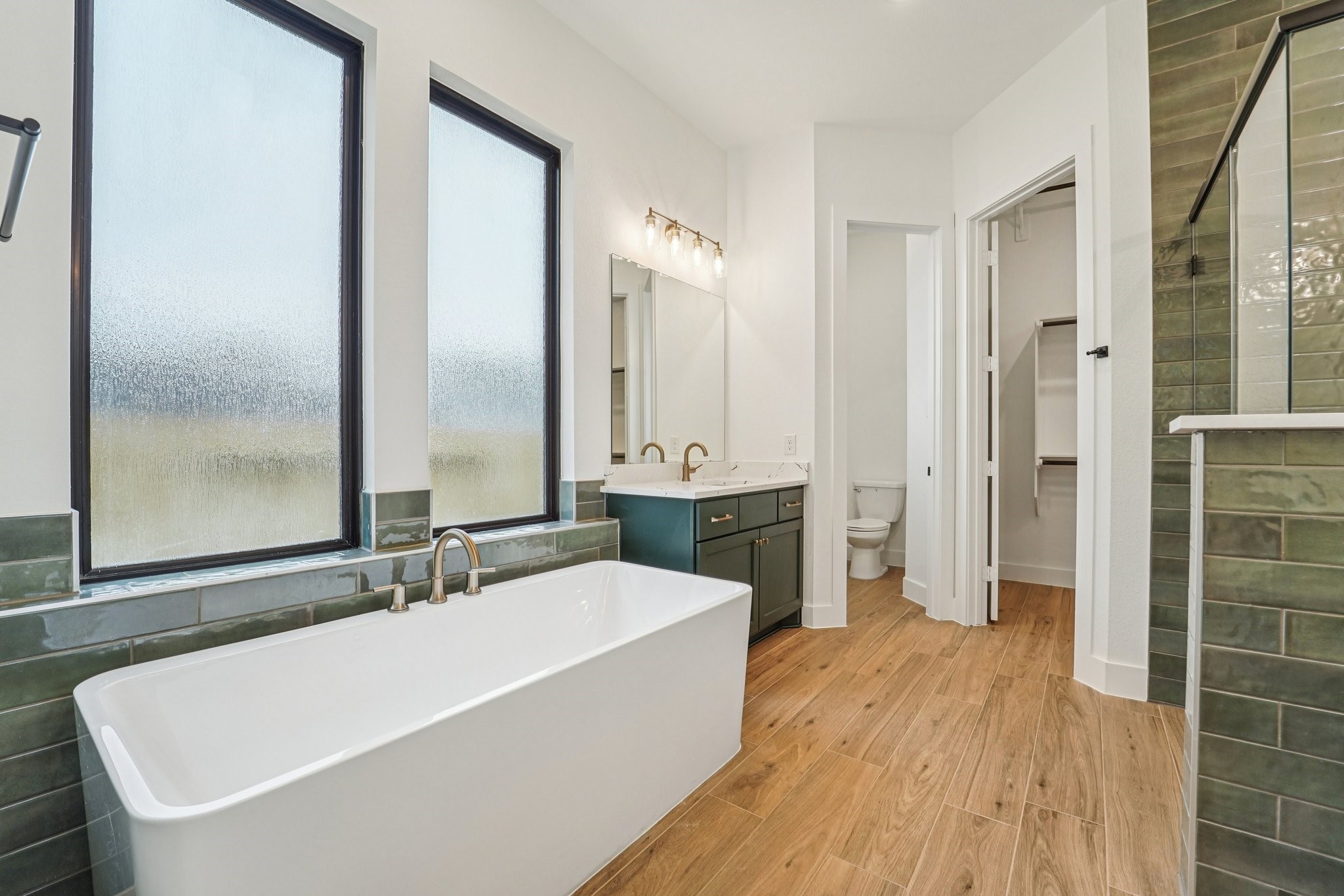 15727 Hoptree Hts Lane Conroe, TX 77302 - Photo 25 of 44 a bathroom with a tub a sink and a large mirror