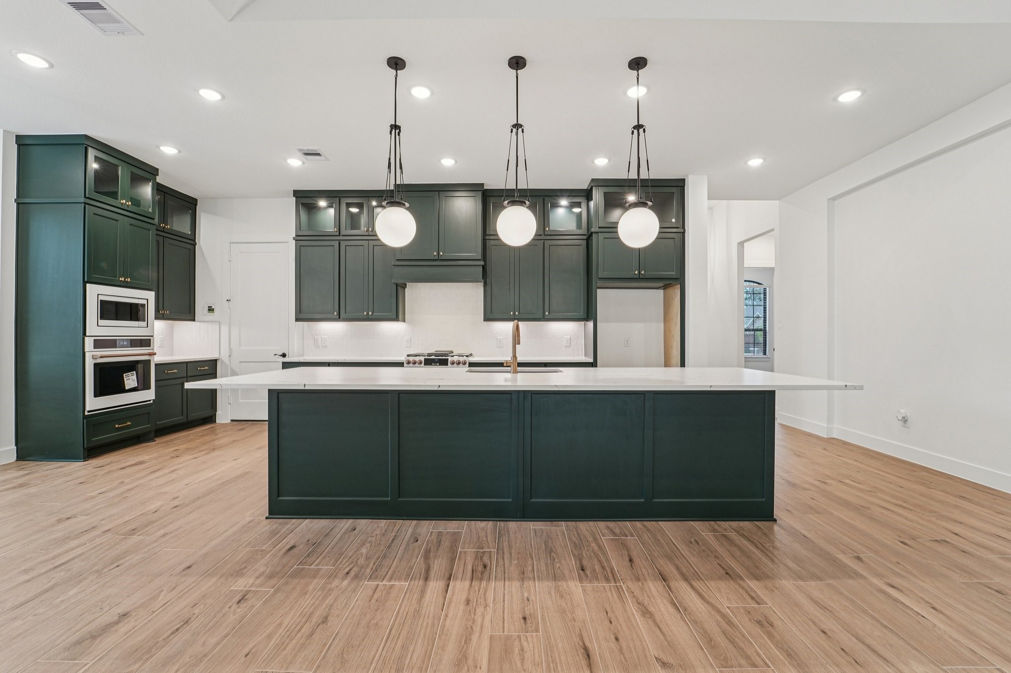 15727 Hoptree Hts Lane Conroe, TX 77302 - Photo 3 of 44 a kitchen with kitchen island stainless steel appliances a sink refrigerator and microwave