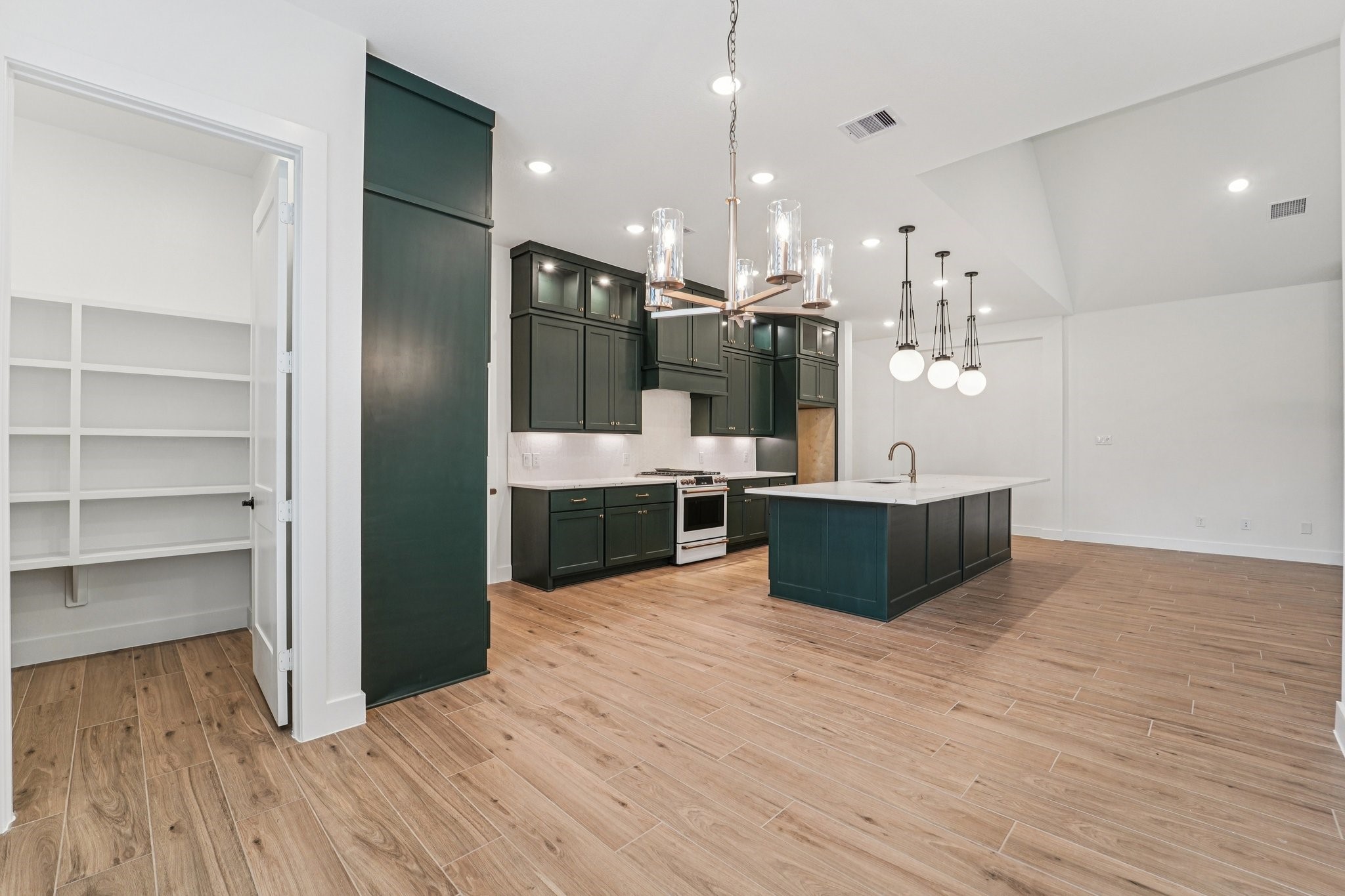 15727 Hoptree Hts Lane Conroe, TX 77302 - Photo 9 of 44 a large kitchen with stainless steel appliances kitchen island a large counter top and a wooden floors