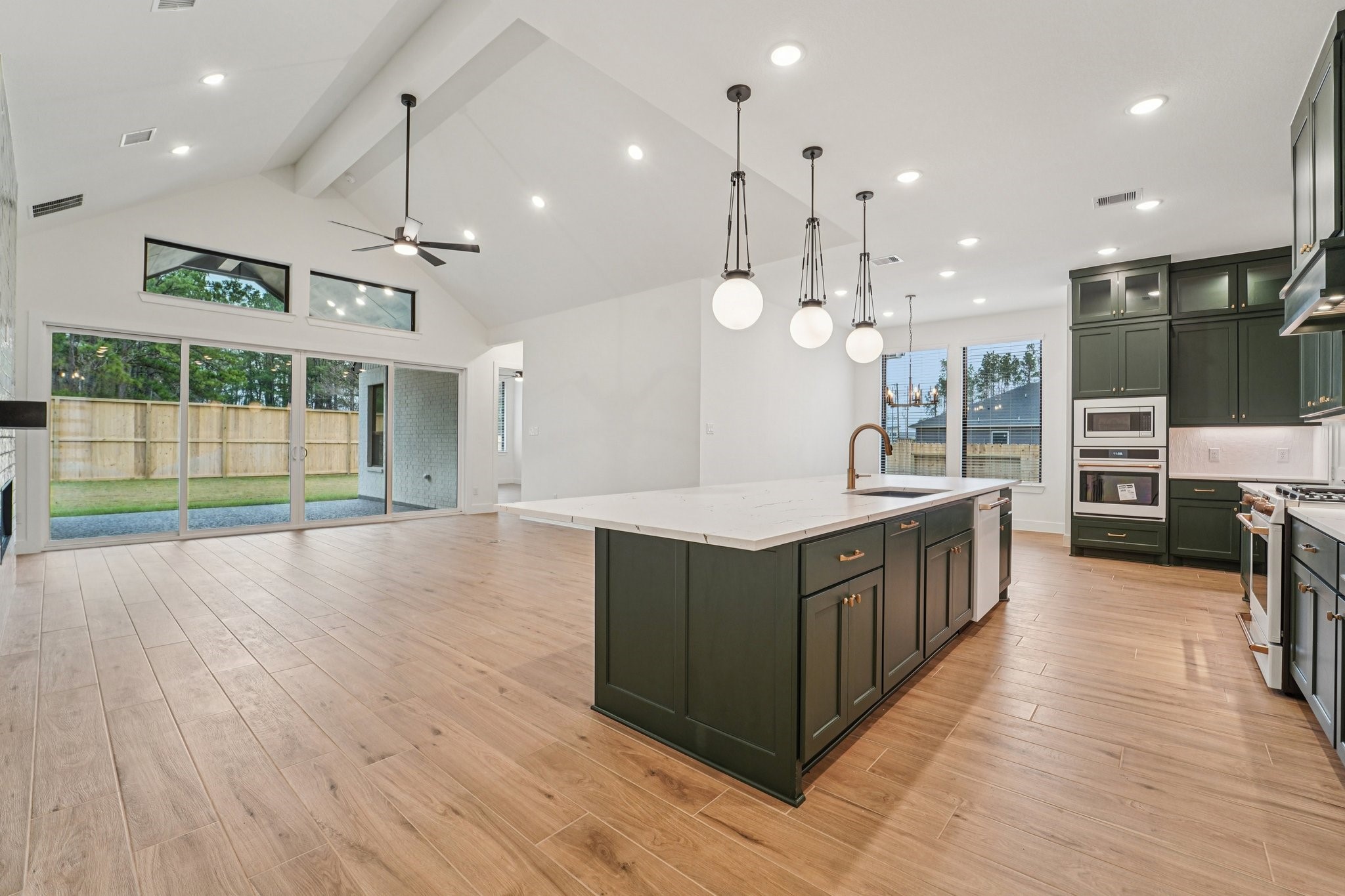 15727 Hoptree Hts Lane Conroe, TX 77302 - Photo 10 of 44 an open kitchen with wooden floor and large windows
