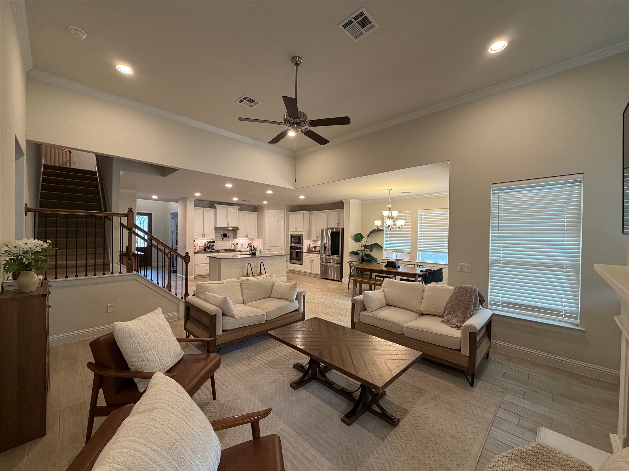 8709 Moccasin Path Austin, TX 78736 - Photo 1 of 34 Living room featuring a ceiling fan, ornamental molding, suspended lighting, and light wood-style flooring