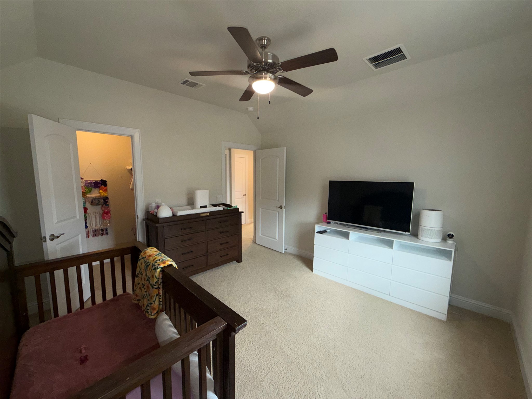8709 Moccasin Path Austin, TX 78736 - Photo 22 of 34 Bedroom with vaulted ceiling, light colored carpet, ceiling fan, and a crib