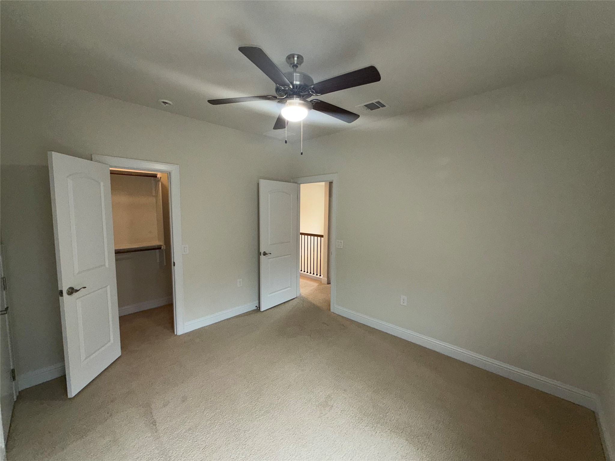8709 Moccasin Path Austin, TX 78736 - Photo 24 of 34 Unfurnished bedroom with a spacious closet, light colored carpet, and a ceiling fan