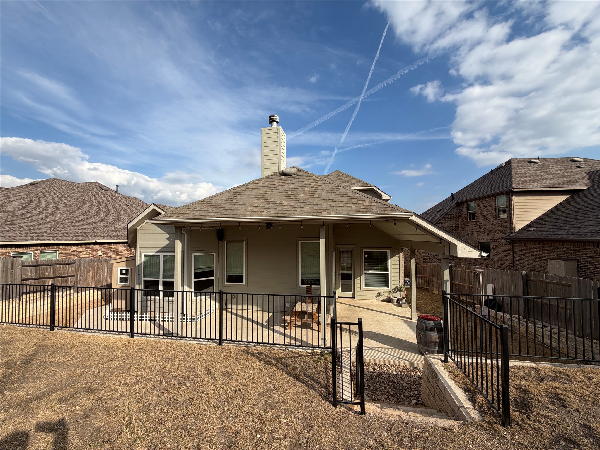 8709 Moccasin Path Austin, TX 78736 - Photo 25 of 34 Rear view of house featuring a patio, roof with shingles, a fenced backyard, and a chimney