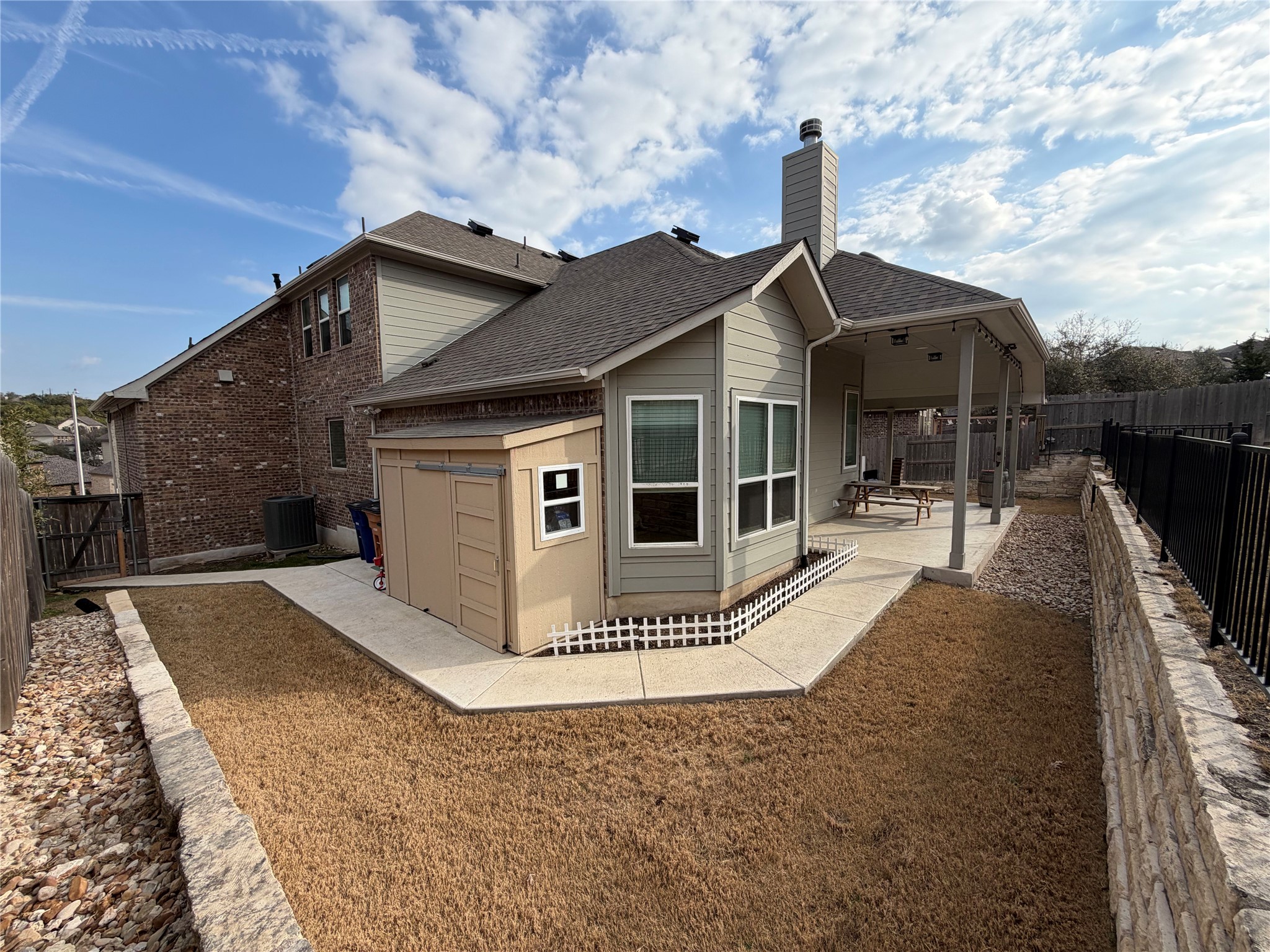 8709 Moccasin Path Austin, TX 78736 - Photo 26 of 34 Rear view of house featuring a patio, a shingled roof, a fenced backyard, and a chimney