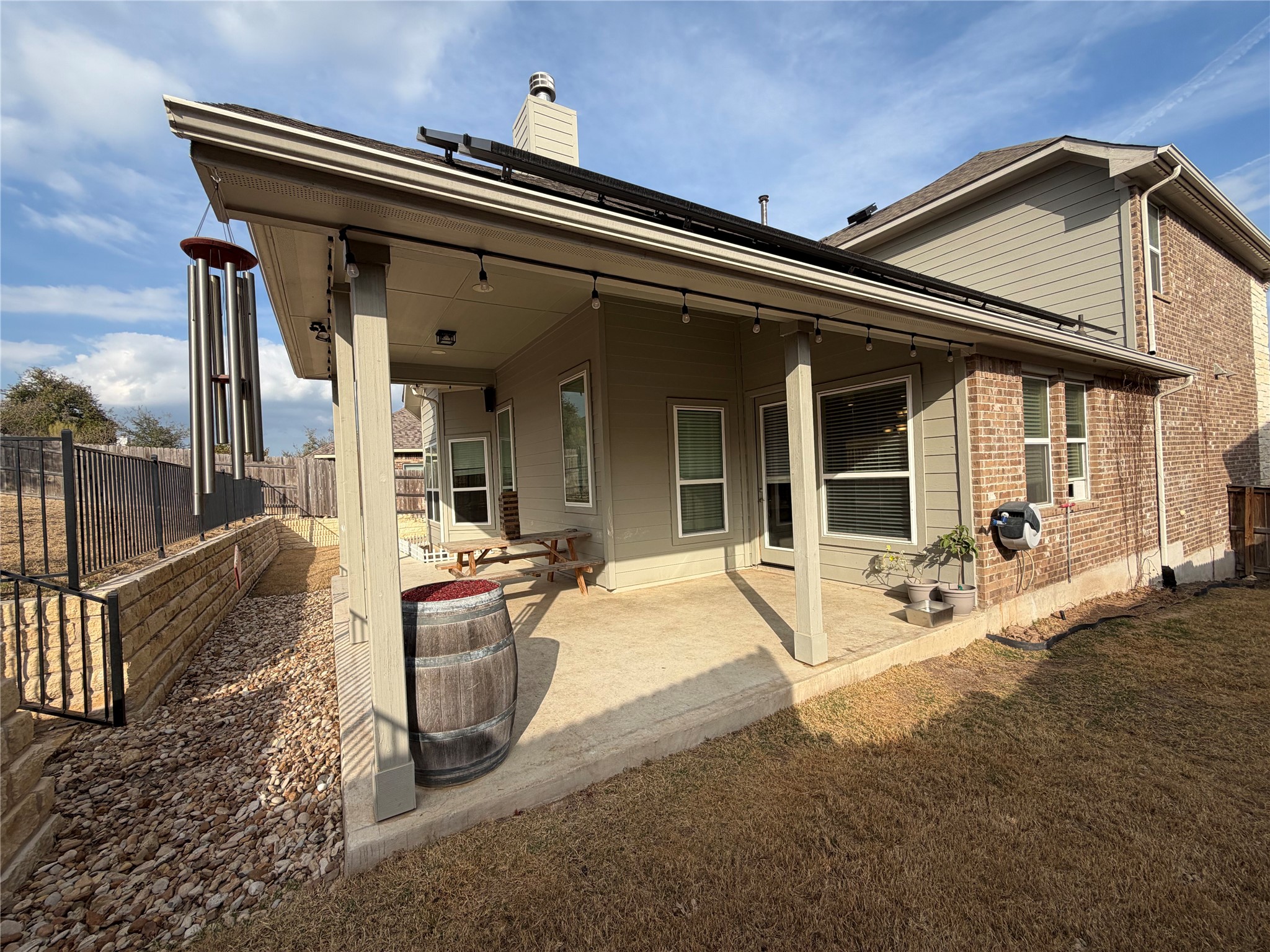 8709 Moccasin Path Austin, TX 78736 - Photo 27 of 34 Back of house featuring a patio, brick siding, a chimney, and a fenced backyard