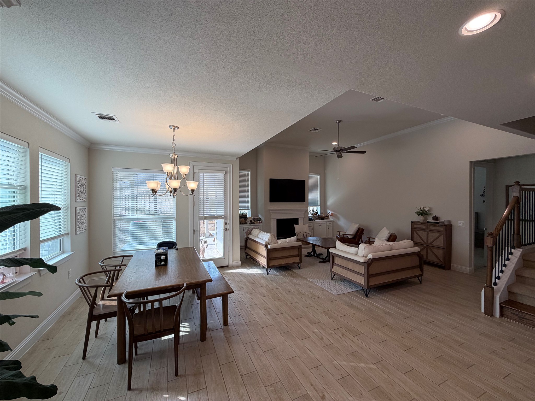 8709 Moccasin Path Austin, TX 78736 - Photo 8 of 34 Dining space with ceiling fan, hanging lights, a textured ceiling, wood tiled floors, and crown molding