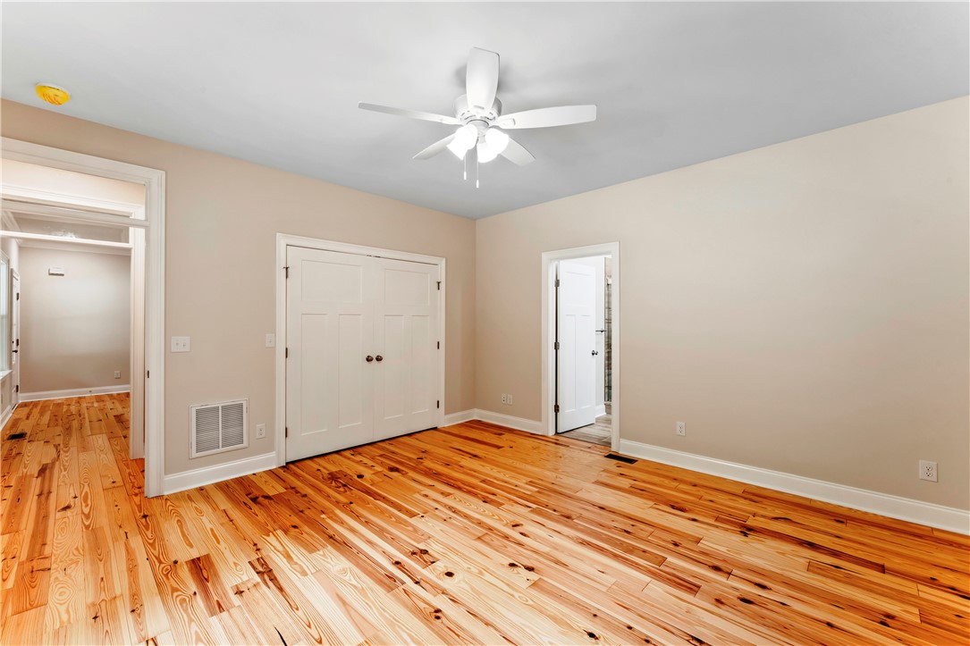 110 Gabriel Way Pickens, SC 29671 - Photo 17 of 48 Natural wood flooring complements this inviting bedroom with a practical closet and ample overhead lighting.