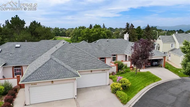 an aerial view of a house with a yard and a large tree