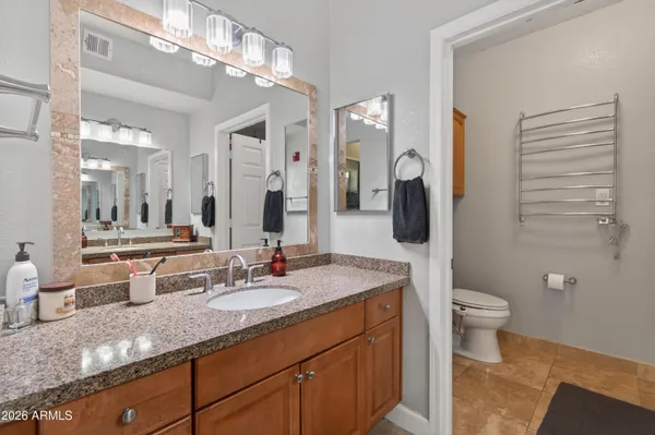 a bathroom with a granite countertop sink a toilet and mirror