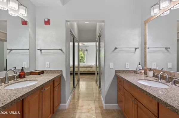a en suite bathroom with a granite countertop sink and a mirror