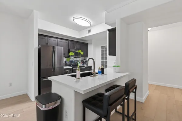 a kitchen with stainless steel appliances a table and chairs