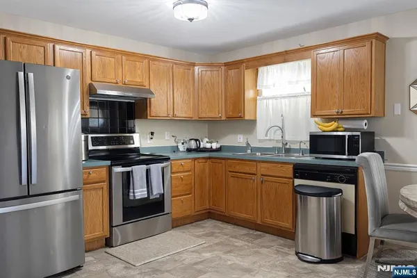 a kitchen with stainless steel appliances granite countertop a refrigerator stove and sink