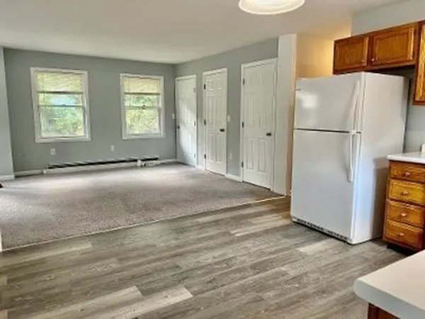a view of a kitchen with furniture and a refrigerator
