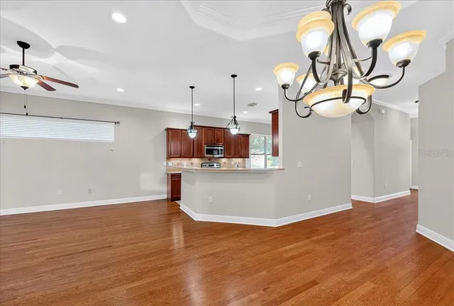 a view of a room with wooden floor and ceiling fan
