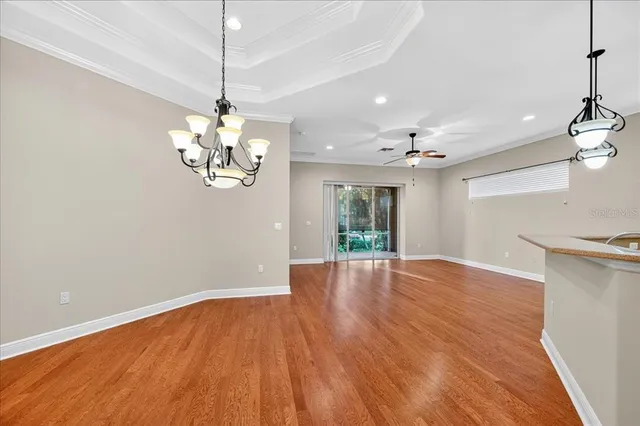 a view of an room with wooden floor chandelier and a window