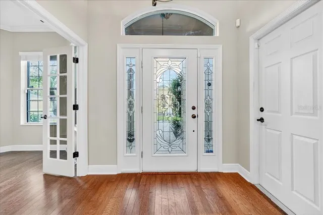 a view of a hallway with wooden floor and entryway