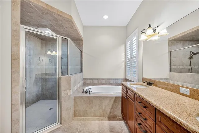 a bathroom with a granite countertop double vanity sink mirror and shower