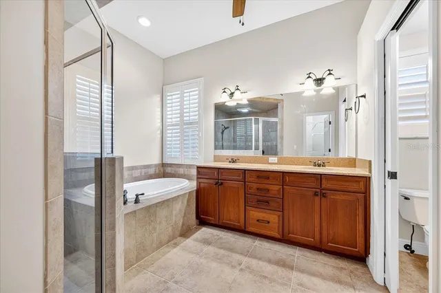 a spacious bathroom with a double vanity sink a large mirror and a bathtub