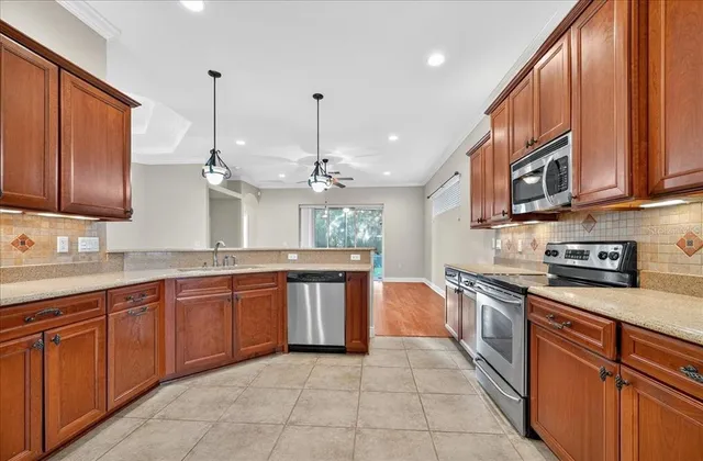 a large kitchen with stainless steel appliances granite countertop a stove a sink dishwasher and a refrigerator