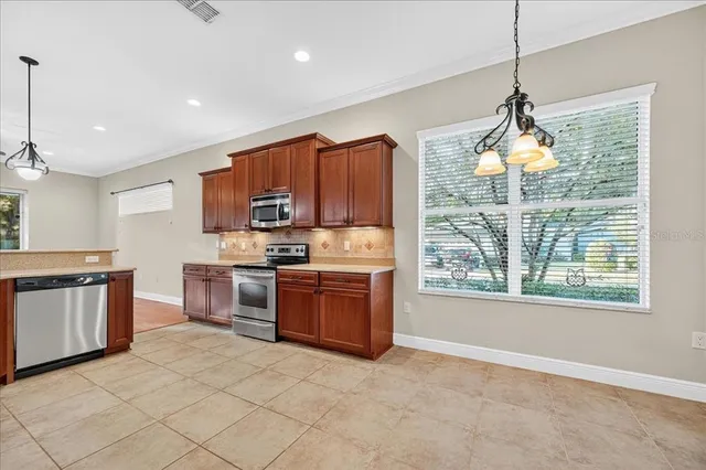 a kitchen with granite countertop a stove top oven a sink dishwasher a dining table and chairs with wooden floor