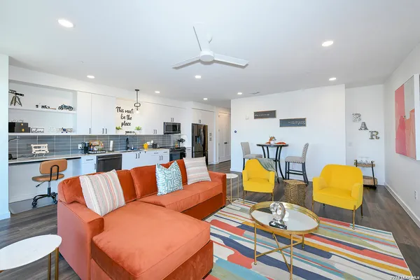 a living room filled with furniture and kitchen view