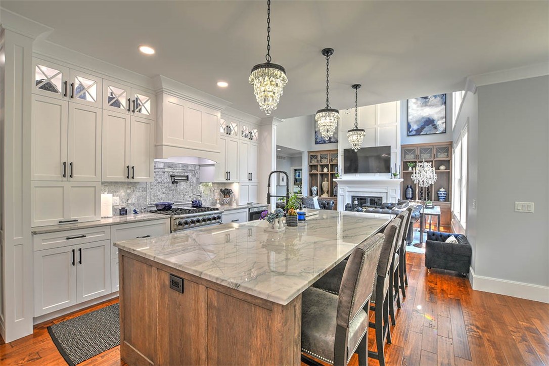 6323 Autumn Ridge Court Decatur, IL 62521 - Photo 12 of 43 a large kitchen with granite countertop a stove a sink a center island and wooden floor