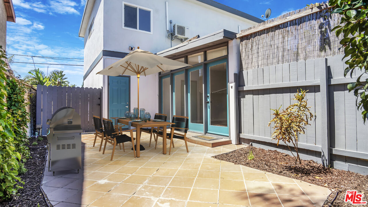 1610 East Carson Street, Unit 3 Long Beach, CA 90807 - Photo 17 of 21 a view of a patio with table and chairs potted plants with wooden fence