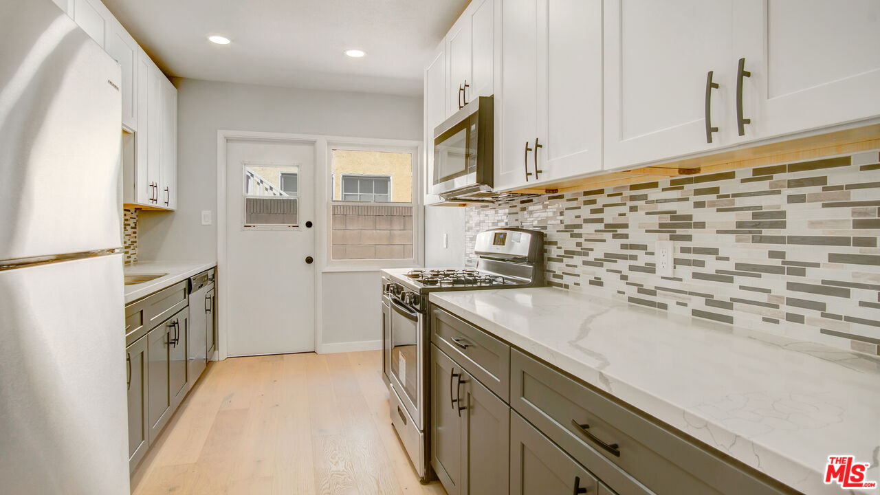1610 East Carson Street, Unit 3 Long Beach, CA 90807 - Photo 4 of 21 a kitchen with stainless steel appliances granite countertop a sink stove and refrigerator