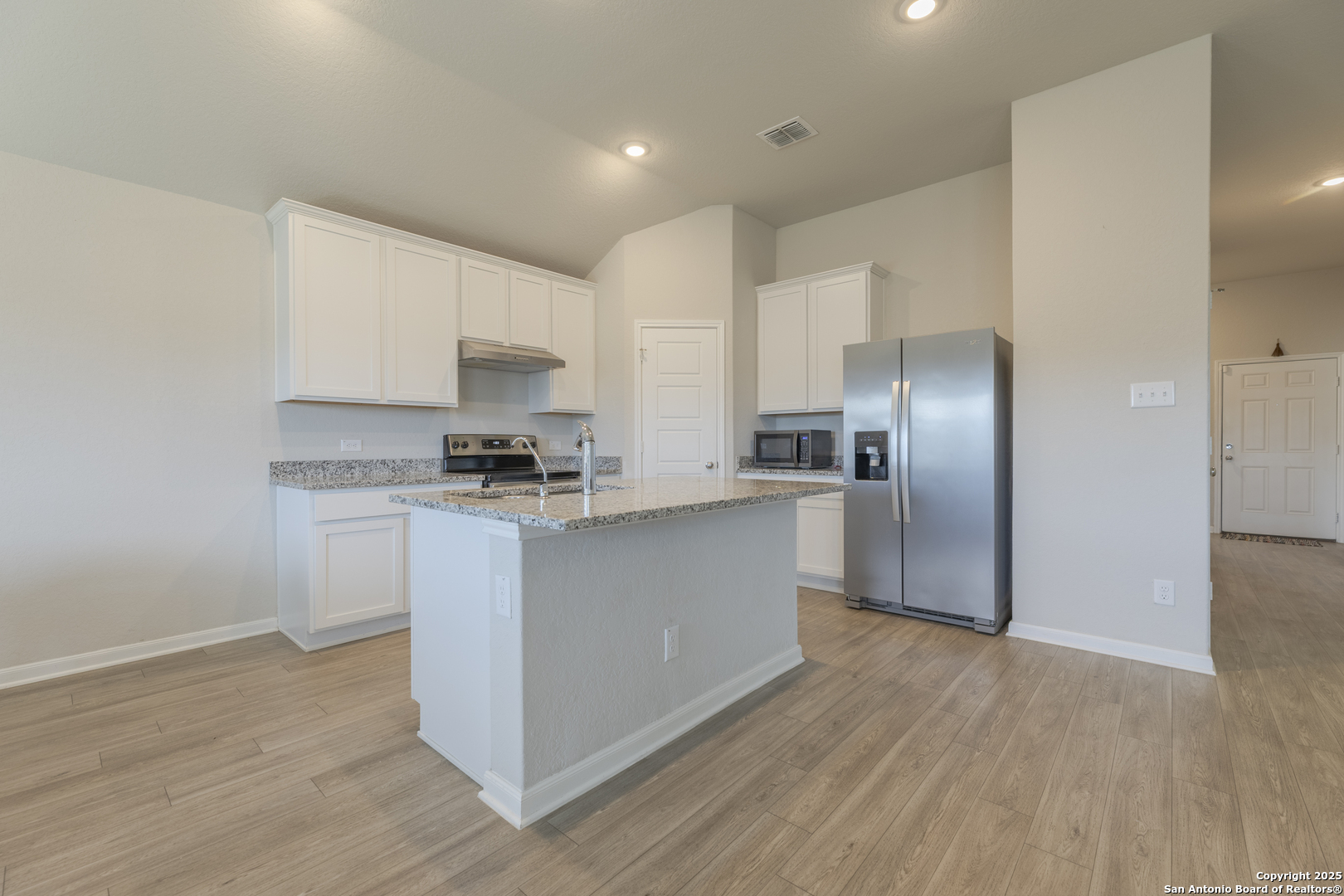 765 Stonemanor Bay Seguin, TX 78155 - Photo 5 of 29 a kitchen with granite countertop a refrigerator and a stove top oven