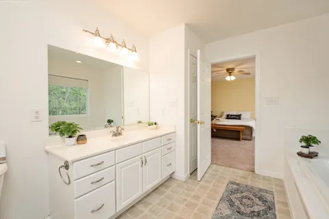a spacious bathroom with a double vanity sink a mirror and a shower