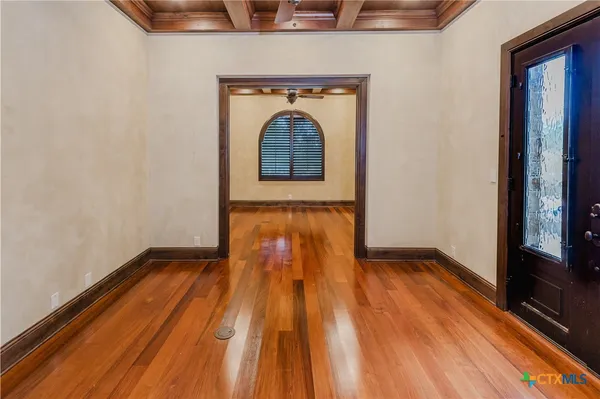 a view of empty room with wooden floor
