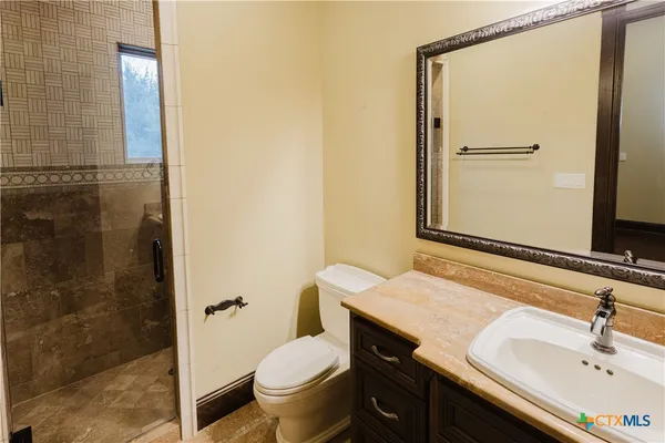 a bathroom with a granite countertop sink toilet and shower